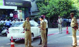 Policemen cordon off the car used in the robbery in New Delhi on Friday.
