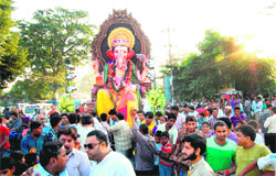 Devotees take a huge idol of Lord Ganesha for immersion in the Brahmkund at 