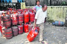 A man carries an LPG cylinder in Jammu on Friday.