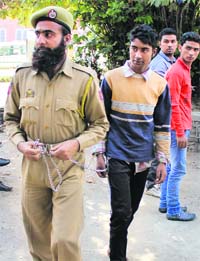 A police personnel takes the boy to a local court in Srinagar on Friday. 