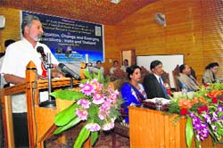 An academician reads a reaserch paper during the international seminar in Srinagar on Friday.