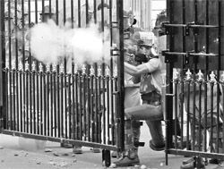  A riot police personnel fires tear gas shell at pro-Telangana supporters during a protest in Hyderabad. 