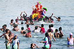 Devotees immerse an idol of Lord Ganesha in the Yamuna in New Delhi on the last day of Ganesh Chaturthi on Friday