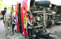 Minibus that turned turtle after it rammed into stray cattle on Bikram Chowk-Satwari highway near Nai Basti in Jammu on Saturday. Tribune photo: Inderjeet Singh