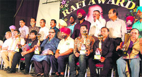 Artistes along with award organisers pose for a photograph during the Mohammad Rafi Award Ceremony in Amritsar on Sunday.
