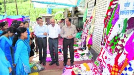 Deputy Divisional Manager, NABARD, Rahul Shashni inspects an exhibition of embroidered articles at Kolka village in Chamba district.