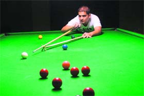 A cueist eyes a target during the ongoing snooker championship in Jammu on Sunday