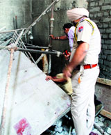 Police officials inspect the site where the shuttering gave way in Ludhiana on Sunday.