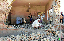 Residents inspect the site of a bomb attack in Taji, about 20 km north of Baghdad on Sunday