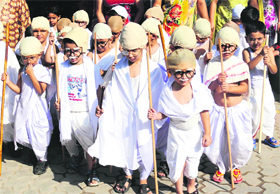 Schoolchildren of DAV Public School dressed as Mahatma Gandhi participate in a school function on the eve of birth anniversary of Mahatma Gandhi in Amritsar on Monday.