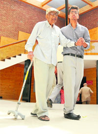 A youth helps his grandfather, who came to attend a felicitation function at the Tagore Theatre, Sector 18, in Chandigarh on Monday.