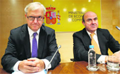 Spanish Economy Minister Luis de Guindos (R) and EU Economic & Monetary Affairs Commissioner Olli Rehn at a news conference in Madrid on Monday. European aid for Spain's troubled banks is expected to arrive in November, Rehn said, while urging the country to stick to its calendar of ambitious economic reforms.  Reuters