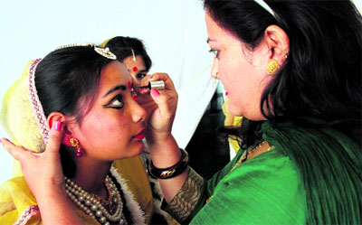 A teacher of the Nritangana Institute of Performing Arts doing the make up of a girl before her performance at a function in Dehradun