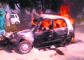 The car on fire after its accident in Palwal on Tuesday