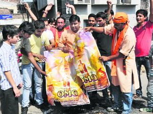 Activists of the Bajrang Dal burn posters of Oh My God, a Hindi movie that contains derogatory comments against Hindu gods, in Jammu on Tuesday. 
