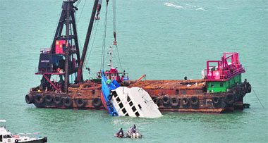 The bow of the Lamma IV boat (C) is seen partially submerged during rescue operations off Hong Kong on Sunday.