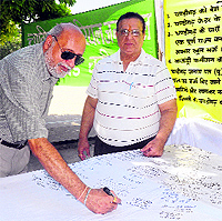 A resident signs on a canvas during a signature campaign launched by the Janata Dal (U) demanding statehood for the City Beautiful at the Sector 17 Plaza in Chandigarh on Wednesday