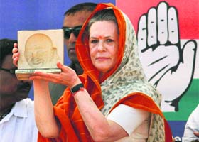 Congress chief Sonia Gandhi with a memento she received at a poll rally in Rajkot on Wednesday