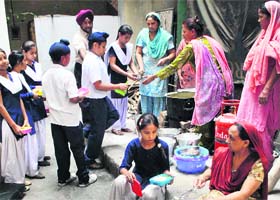 Mid-day meal being served to children at a school in Patiala on Wednesday