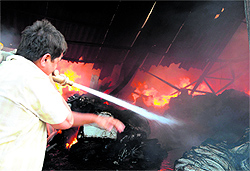Workers try to save bundles of clothes from fire