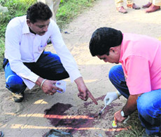 Forensic experts take samples of blood from the spot where a balloon seller was found murdered in Sector 1, Chandigarh, on Thursday.