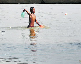 A boy looks for coins thrown by devotees in Sutlej.