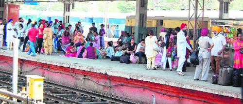Stranded passengers wait for the arrival of their trains at Amritsar railway station on Friday.