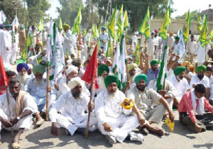 Farmers squat on the Bathinda-Barnala road to protest against the hike in fuel price. 