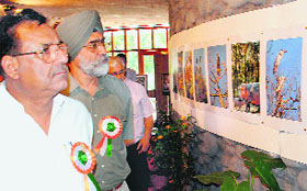 Surjit Kumar Jyani (left), Punjab Forest Minister, looks at photographs at an exhibition organised during Wildlife Week at the Chhatbir Zoo on Friday.