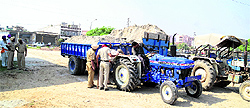Police officials impound the sand-laden tractor-trailers in Ludhiana on Friday