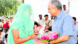 DC Chander Shekhar is welcomed by sarpanch Seema.