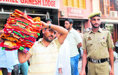 JMC staff remove encroachments at Hari market in Jammu on Saturday. Tribune photo: Inderjeet Singh