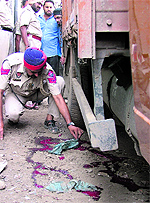 A policeman examines blood stains at the blast site in Ludhiana