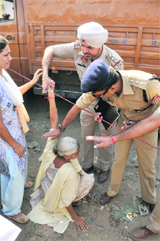 A police official tries to pacify the relative of a victim.