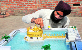 Gurpreet Singh shows his miniature replica of the Golden Temple made of paper in Amritsar.