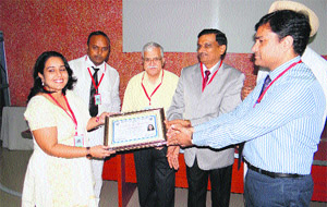 Judges Harish Gupta and Subhash Goyal present a certificate to a participant at a convention of the District Legal Services Authority in Sirsa. 