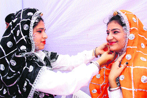 A participant gives the final touches to another participant during the zonal youth festival at Pt Neki Ram Sharma Government College in Rohtak on Sunday. 