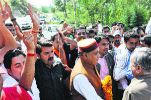 Chief Minister PK Dhumal is greeted by party workers at Ukhali in Hamirpur district on Sunday.