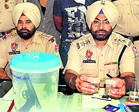Police officials show the air pistol, gold chains and narcotics seized from the duo in Jalandhar on Sunday