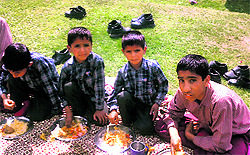 Students eat mid-day meal at a middle school in north Kashmir