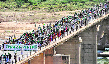 Tribesmen and landless farmers cross 'Rajghat Bridge' over the Chambal river to enter Dhaulpur, Rajashthan, on Saturday