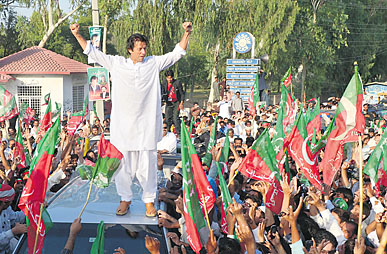 Imran Khan gestures as he stands on a vehicle during a rally in Mianwali.