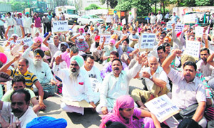 Members of the Northern Railway Mens Union hold a protest on the road leading from the railway station to Circuit House in Amritsar on Monday. 