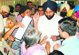 Punjab Revenue Minister Bikram Singh Majithia listens to the grievances of people during a surprise inspection of tehsil complex in Amritsar on Monday. 