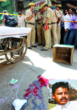 Policemen inspect the spot where Sultan Ahmad (inset) was shot by robbers on Monday.