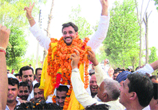 Ram Kumar, BJP candidate from Haroli, being welcomed by workers in Una on Monday.