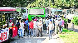Passengers who were travelling in CTU buses wait for services to be resumed as UT police officials try to pacify the agitating bus drivers on the road separating Sectors 35 and 36 in Chandigarh on Tuesday