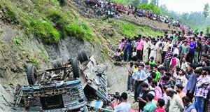 People gather at the Baba Reshi shrine near Gulmarg after a school bus rolled into a gorge, killing three persons, including a child, and injuring 50 others. 
