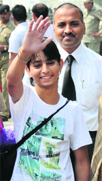 Attired in a new set of clothes, a delighted Kasif waves at his well-wishers in India before crossing over to Pakistan. 