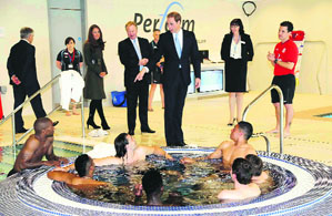 Prince William chats with football player Jermaine Defoe as he and Catherine, Duchess of Cambridge, visit the gym at the new National Football Centre in Burton-upon-Trent, England, on Tuesday.